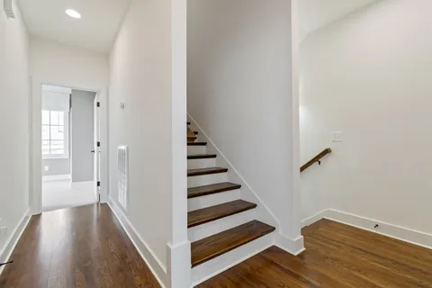 a view of a hallway with wooden floor and entryway