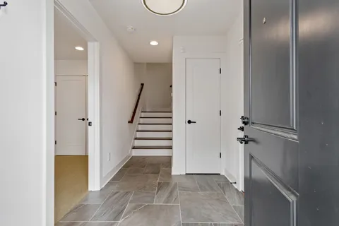 a view of a hallway with wooden floor and staircase