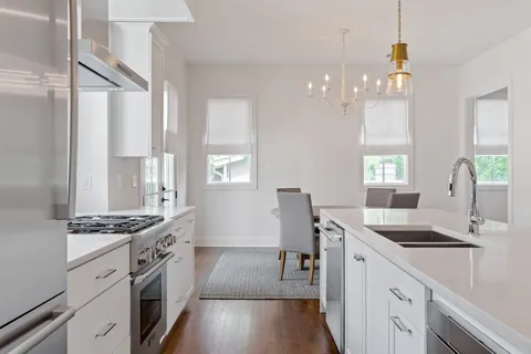 a kitchen with granite countertop a sink cabinets a window and stainless steel appliances