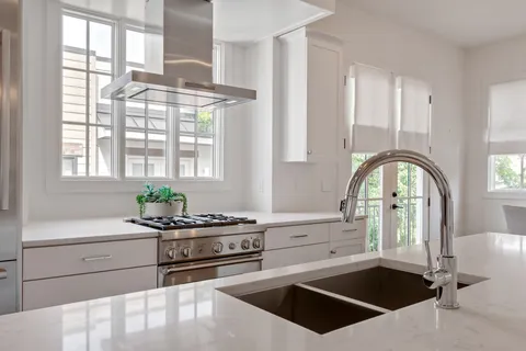a kitchen with stainless steel appliances a sink a stove and a window