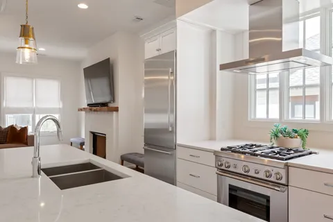 a kitchen with granite countertop a stove a sink and a refrigerator