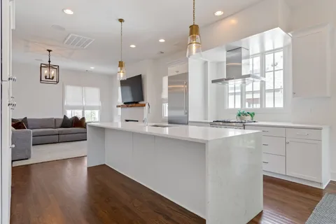 a large white kitchen with lots of counter space and a sink
