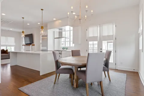 a view of a dining room and livingroom with furniture wooden floor a rug