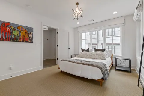 a spacious bedroom with a bed and a chandelier