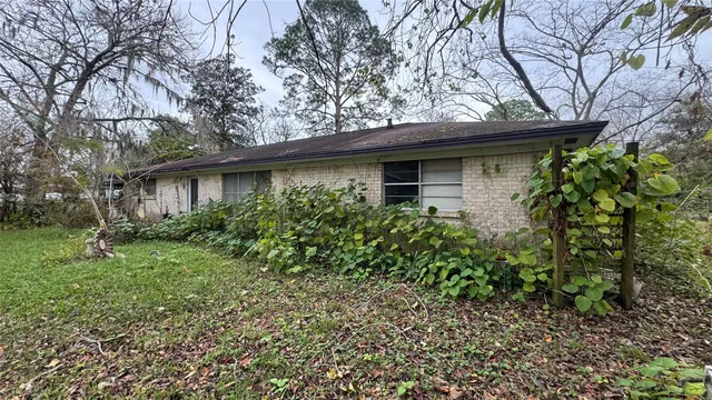a backyard of a house with table and chairs under an umbrella