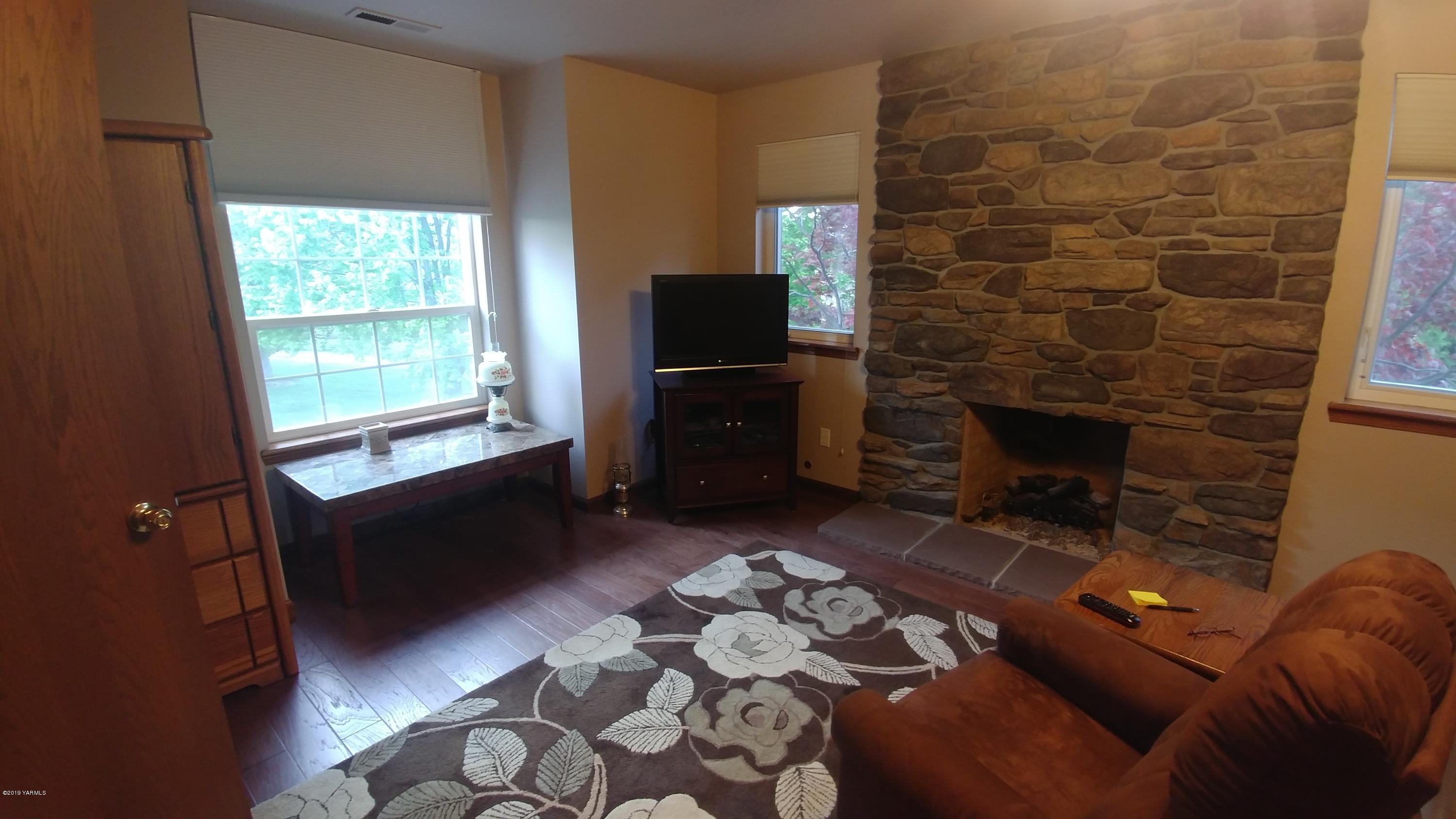 2001 Moore Road Yakima, WA 98908 - Photo 17 of 36 a living room with furniture a flat screen tv and a fireplace