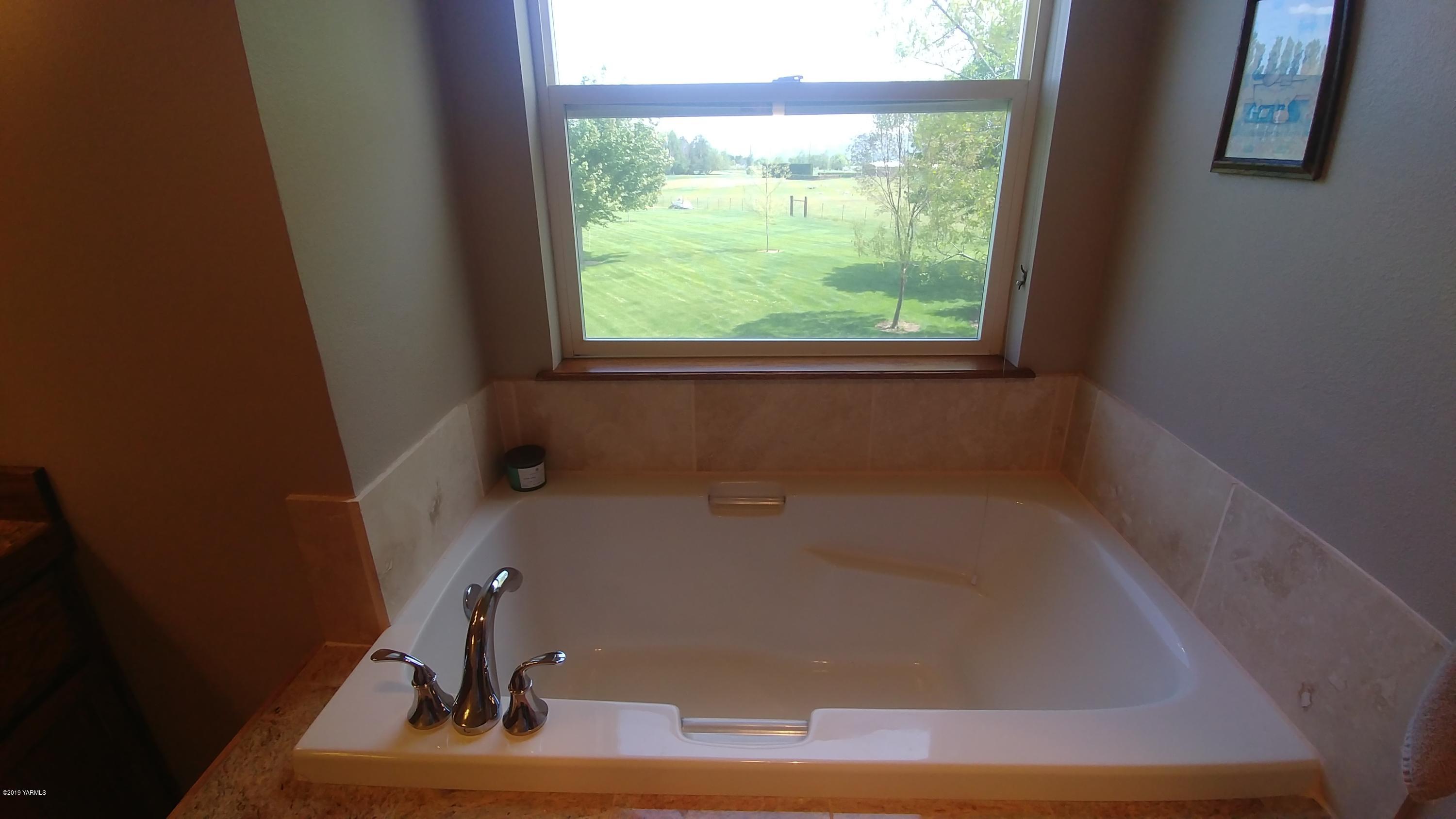 2001 Moore Road Yakima, WA 98908 - Photo 19 of 36 a bath tub sitting in a bathroom next to a window