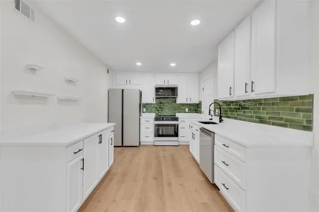 a kitchen with white cabinets and white appliances