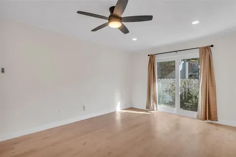 en empty room with ceiling fan and window