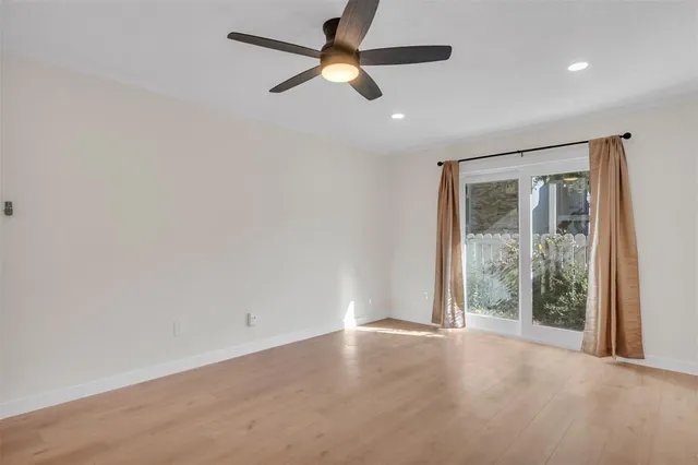 en empty room with ceiling fan and window