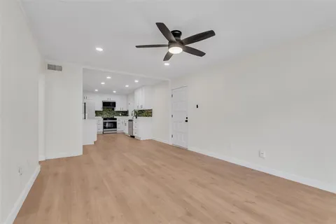 a view of kitchen with stainless steel appliances refrigerator oven and white cabinets