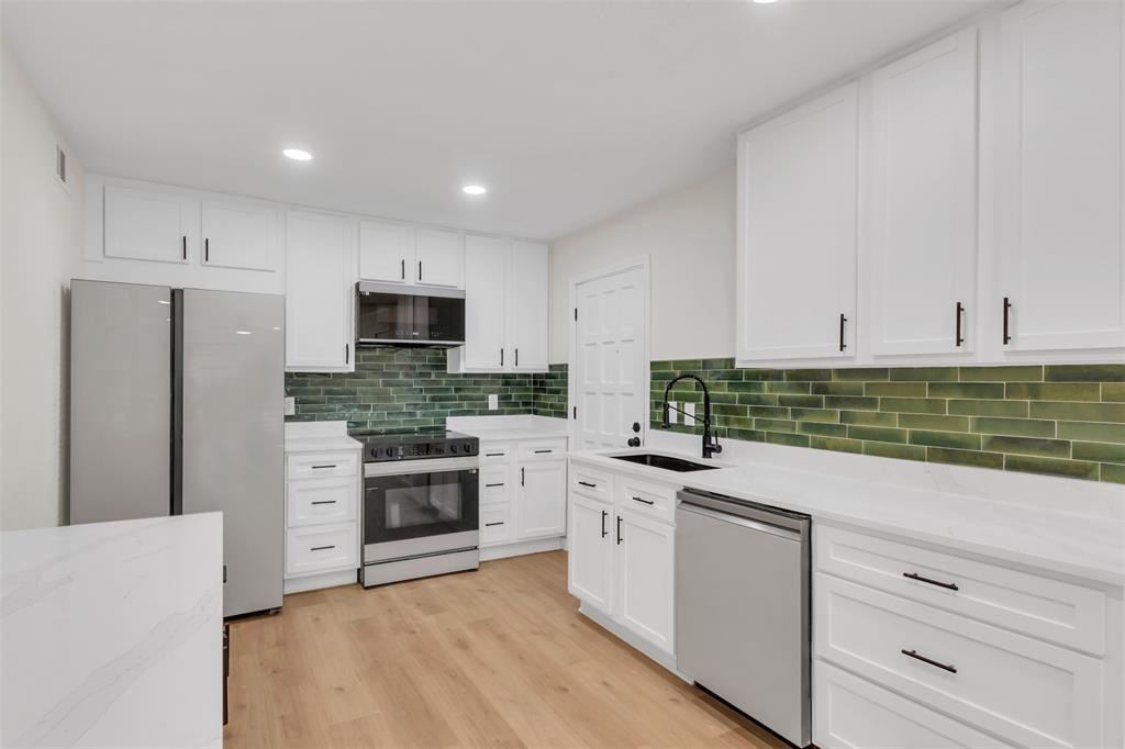 6077 Milton Street, Unit 137 Dallas, TX 75206 - Photo 5 of 15 a kitchen with granite countertop white cabinets and stainless steel appliances