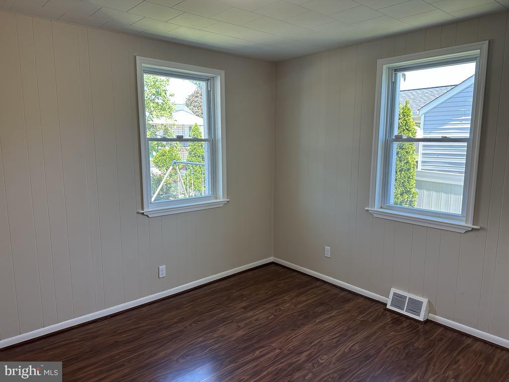 308 Pinewood Road Baltimore, MD 21222 - Photo 12 of 21 an empty room with wooden floor and windows