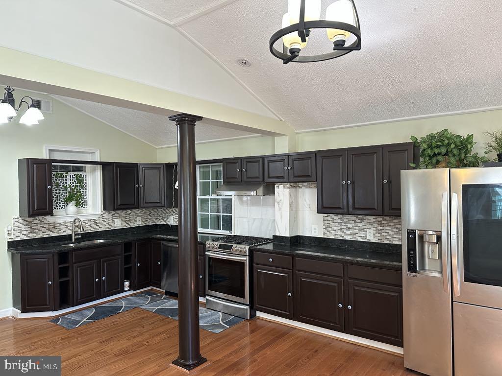 308 Pinewood Road Baltimore, MD 21222 - Photo 5 of 21 a kitchen with granite countertop a refrigerator and a stove top oven