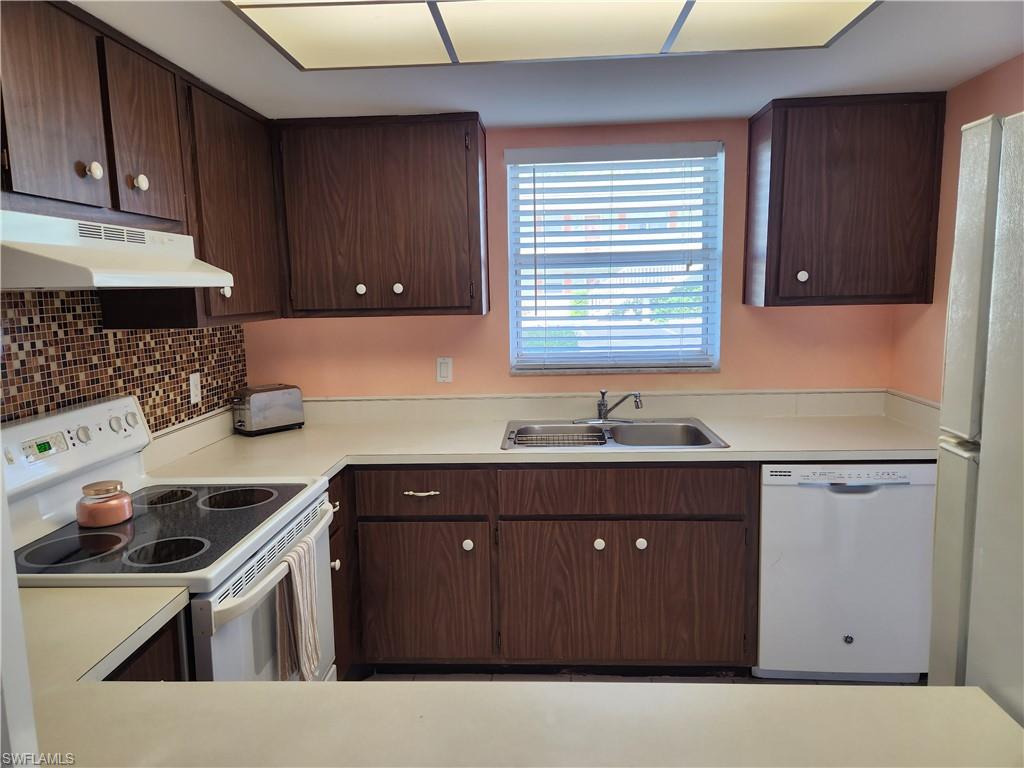 300 Valley Stream Drive, Unit D5 Naples, FL 34113 - Photo 2 of 12 a kitchen with a sink a stove and cabinets