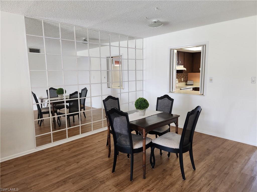 300 Valley Stream Drive, Unit D5 Naples, FL 34113 - Photo 5 of 12 a view of a dining room with furniture and wooden floor