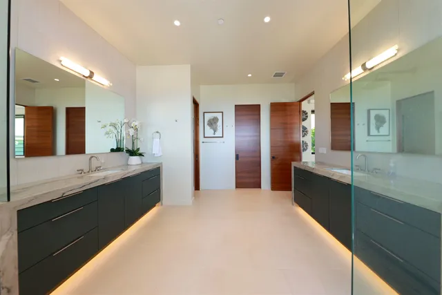 a large bathroom with a large mirror vanity and a sink