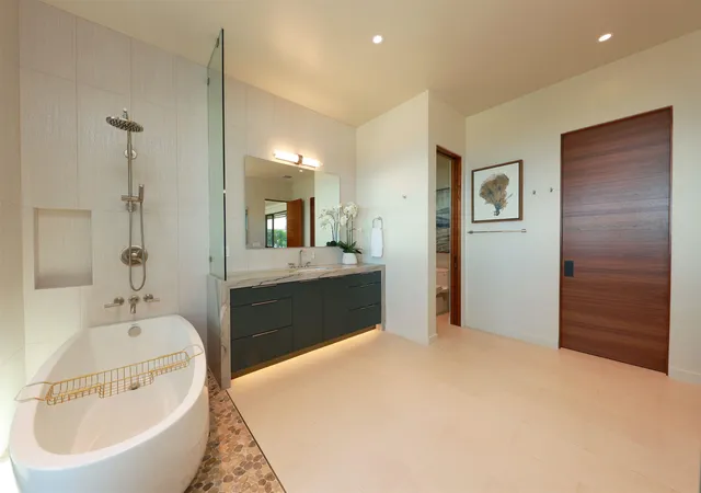 a en suite bathroom with a tub sink and mirror