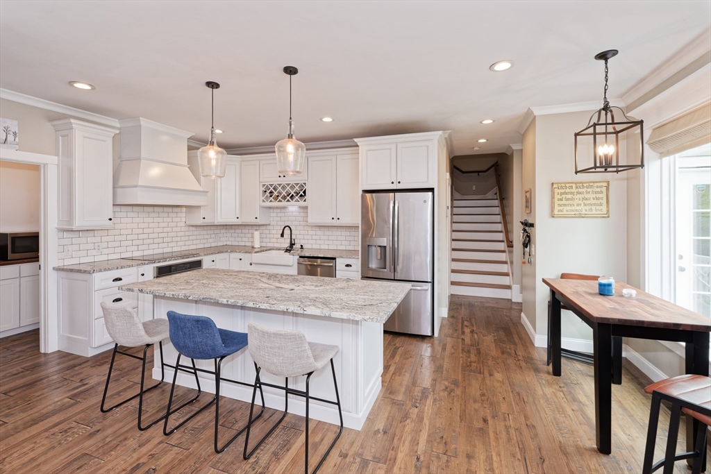 146 7 Bridge Road Lancaster, MA 01523 - Photo 15 of 42 a kitchen with stainless steel appliances granite countertop a kitchen island hardwood floor sink stove dining table and chairs