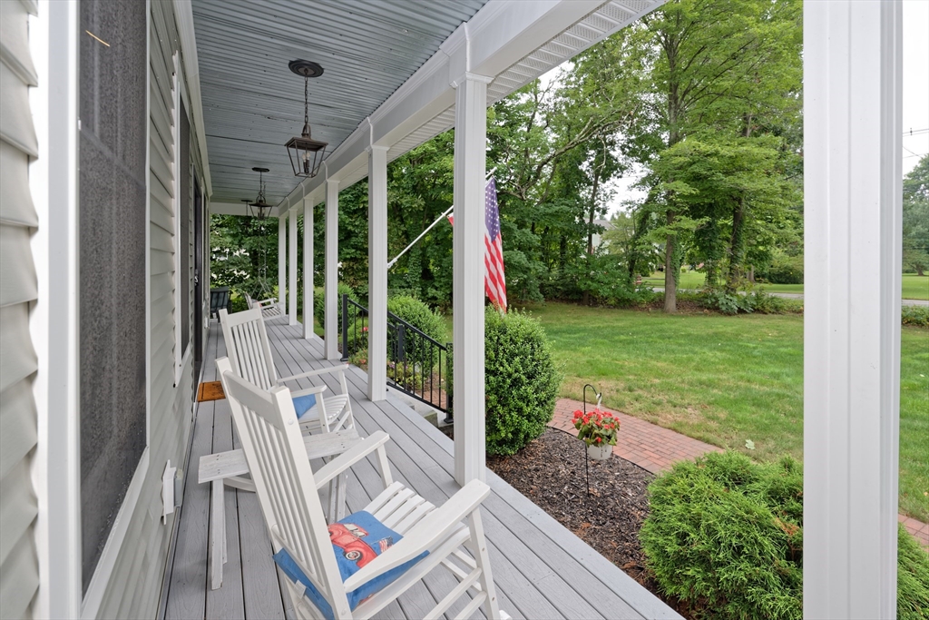 146 7 Bridge Road Lancaster, MA 01523 - Photo 42 of 42 a view of a patio with lawn chairs floor to ceiling window and wooden floor