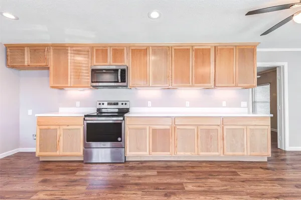a kitchen with stainless steel appliances granite countertop a stove a sink and a microwave