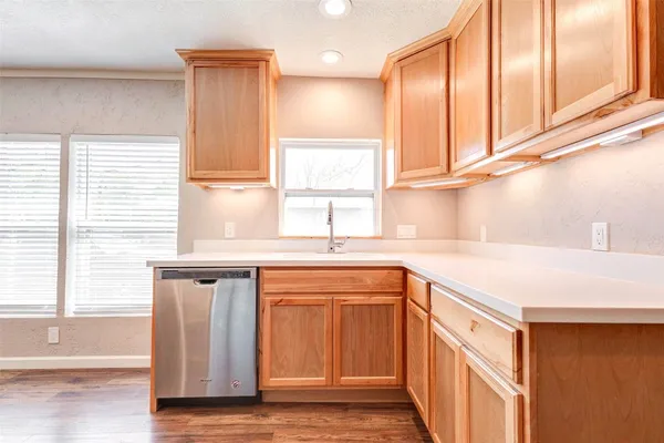 a kitchen with stainless steel appliances granite countertop a sink and cabinets with wooden floor