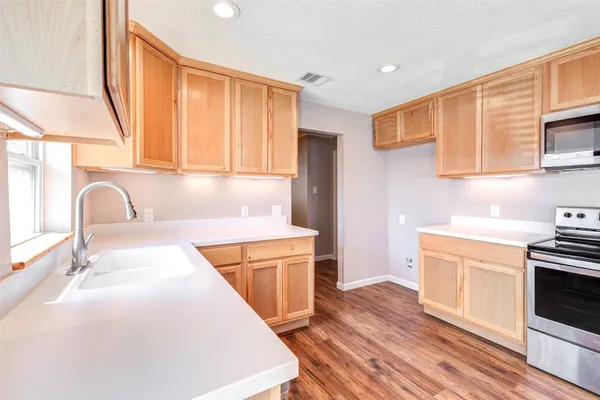 a kitchen with stainless steel appliances granite countertop a sink and a stove