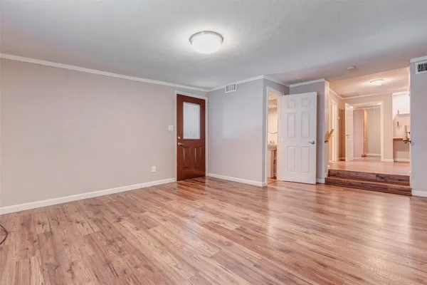 a view of an empty room with wooden floor