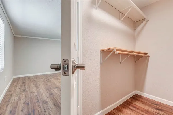 a view of a room with wooden floor and white walls