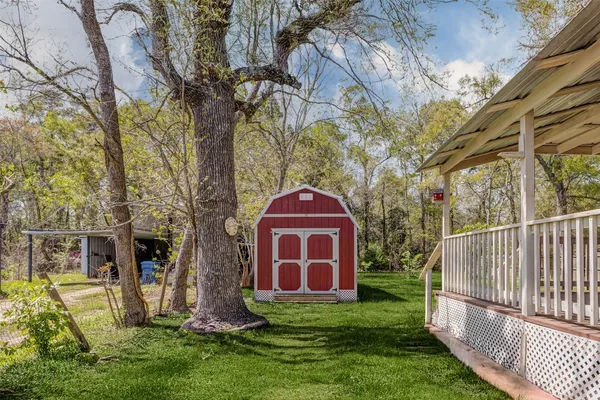 a view of a yard in front of a brick house with a large tree