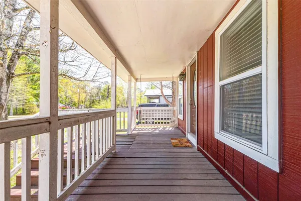 a view of a porch with wooden floor and furniture