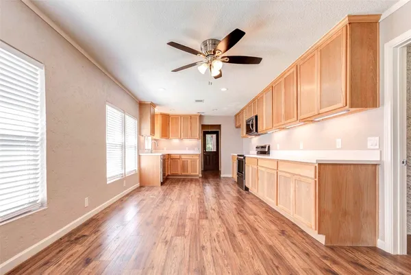 a kitchen with stainless steel appliances a window and wooden floors