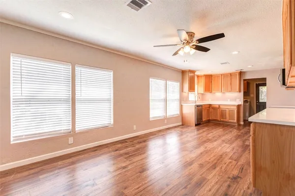 a view of an empty room with window and wooden floor