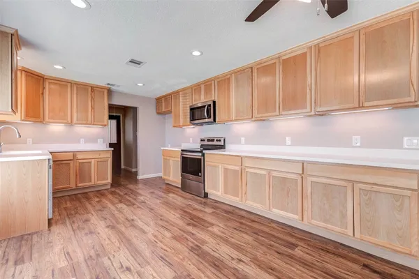 a kitchen with granite countertop a sink cabinets stainless steel appliances and a counter space