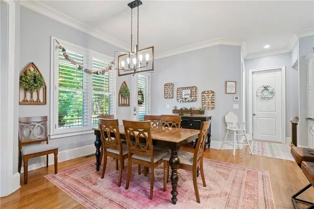 a kitchen with stainless steel appliances granite countertop a stove top oven a refrigerator a stove and white cabinets with wooden floor