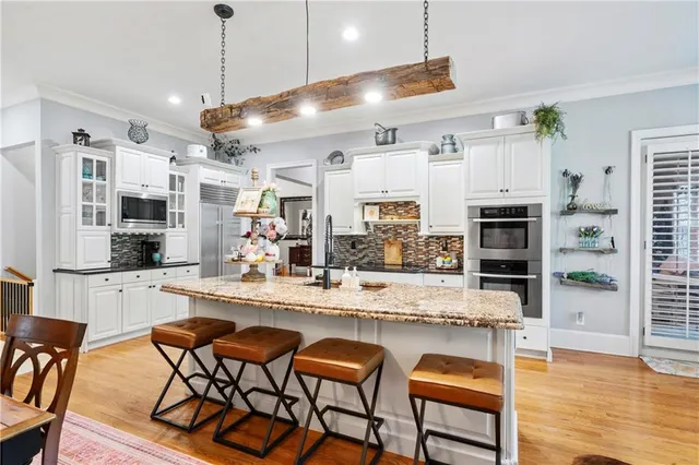 a large kitchen with kitchen island a large counter top space a sink stainless steel appliances and cabinets