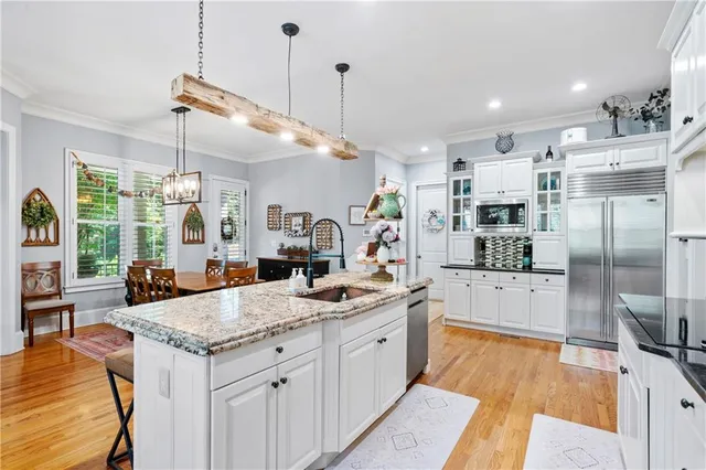 a view of a dining room and livingroom with furniture wooden floor a chandelier