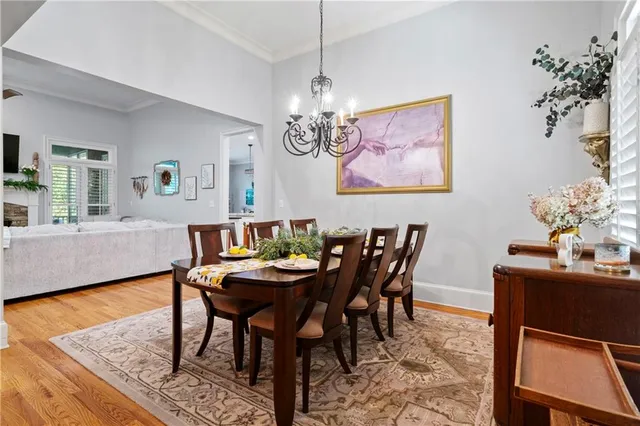 a view of a dining room with furniture a chandelier and wooden floor
