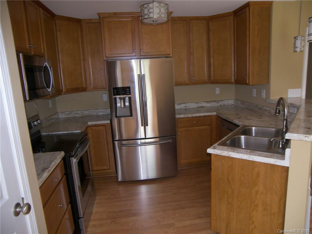 8275 Castor Road, Unit L3 Salisbury, NC 28146 - Photo 11 of 19 a kitchen with metallic refrigerator sink and wooden cabinets
