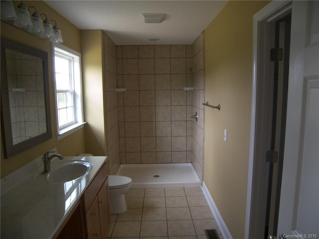 8275 Castor Road, Unit L3 Salisbury, NC 28146 - Photo 13 of 19 a bathroom with a granite countertop sink a toilet and shower