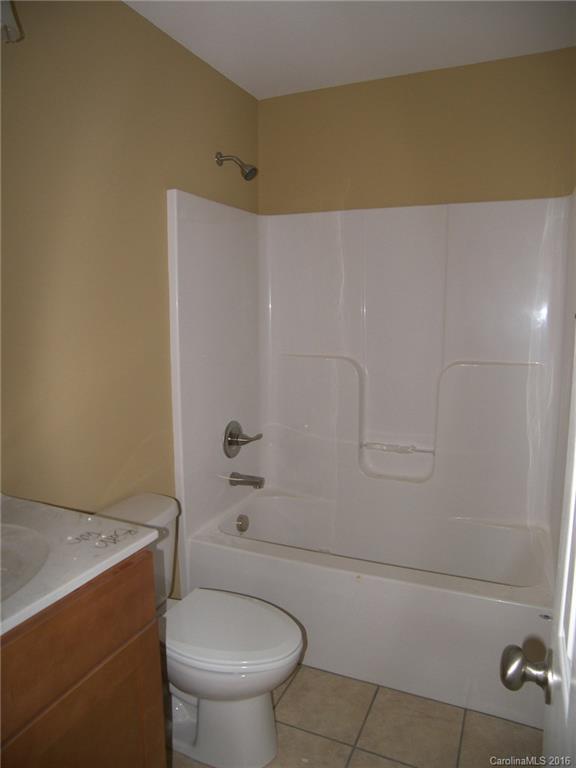 8275 Castor Road, Unit L3 Salisbury, NC 28146 - Photo 18 of 19 a bathroom with a granite countertop toilet and a shower