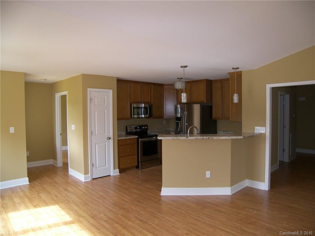 8275 Castor Road, Unit L3 Salisbury, NC 28146 - Photo 5 of 19 a living room with stainless steel appliances kitchen island granite countertop a refrigerator a stove top oven and a wooden floor