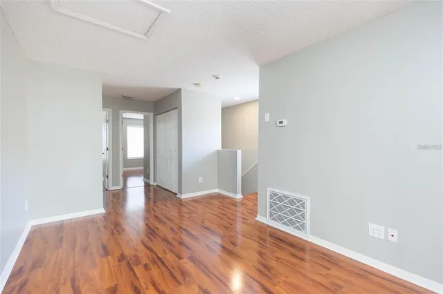 a view of an empty room with wooden floor