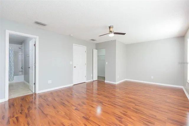 a view of empty room with wooden floor