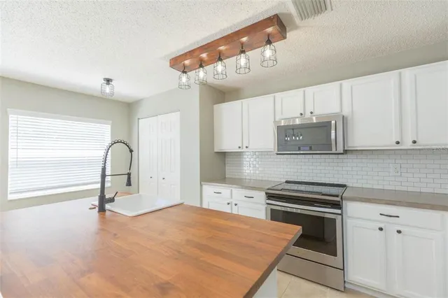 a kitchen with kitchen island a stove cabinets and wooden floor