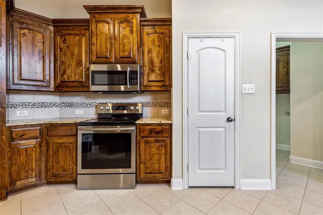 a kitchen with stainless steel appliances granite countertop a refrigerator and a stove top oven