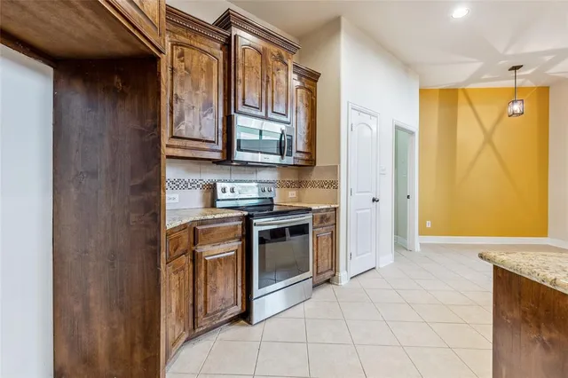 a kitchen with stainless steel appliances granite countertop a stove a sink and a refrigerator