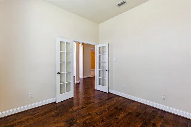 an empty room with wooden floor and closet