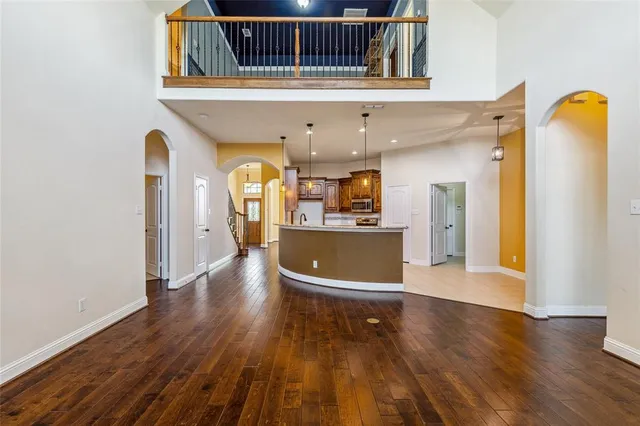 a view of a kitchen with a fridge and wooden floor