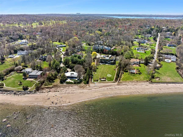 an aerial view of ocean and residential houses with outdoor space